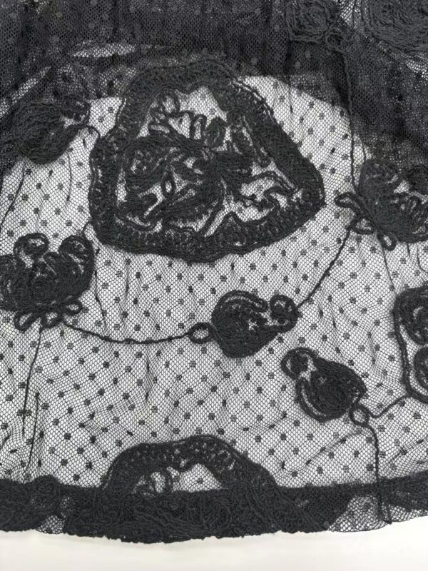 Close-up of black lace fabric with floral patterns and mesh background, ideal for stylish clothing and accessories.