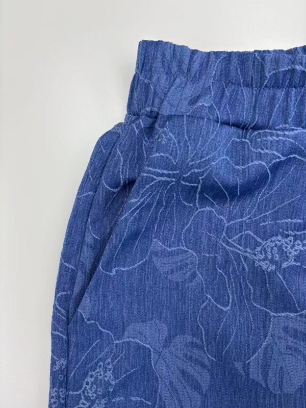 Close-up of blue lounge pants with floral pattern, elastic waistband, and relaxed fit, ideal for casual wear and comfort.