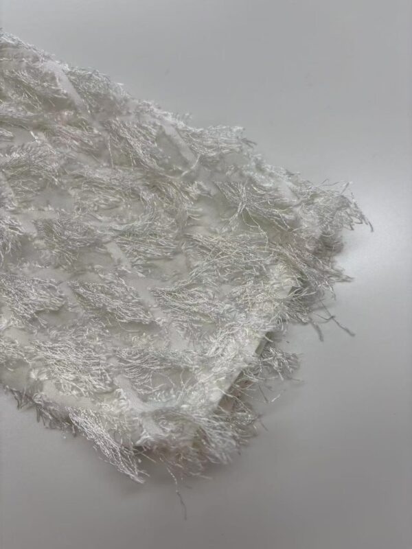 Close-up of delicate white lace fabric with intricate patterns, ideal for fashion and apparel design.