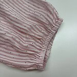 Close-up of pink fabric with white and pink stripes, decorated with small silver dots, gathered at the edge.