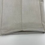 Close-up of beige fabric material showing smooth texture and stitching details, ideal for fashion and clothing design.