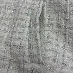 Close-up of a gray fabric with a textured, woven pattern, suitable for fashion or textile product displays.