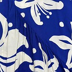 Close-up of a vibrant blue dress with large white floral patterns, featuring a gathered detail and flowing fabric, perfect for summer or casual wear.