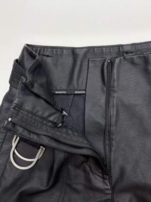 Close-up of black leather pants with zipper and drawstring details, showcasing a sleek and modern design for fashionable men's wear.