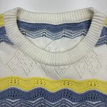 Close-up of a men's knitted sweater featuring white, yellow, and blue patterns with a round neckline, suitable for casual wear.