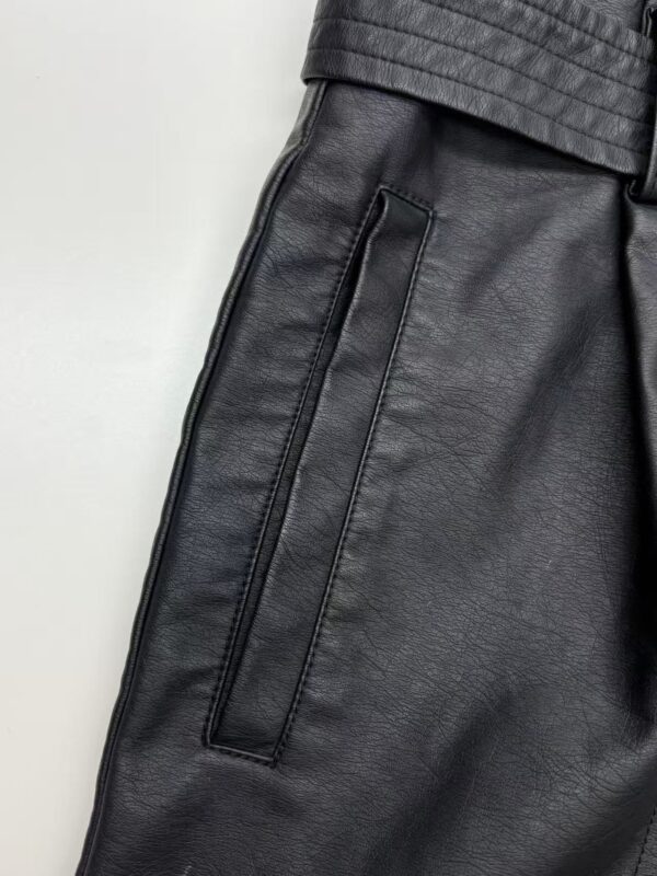 Close-up of black leather pants with zipper pocket, showcasing high-quality material and modern design for fashion-forward men.