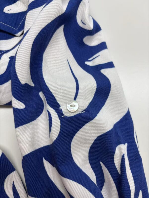 Close-up of a stylish blue and white patterned fabric with a button, ideal for fashion and textile design.