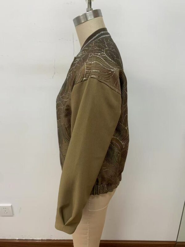Close-up of a women's brown and gold patterned sweater with a round neckline, displayed on a mannequin against a plain white background.