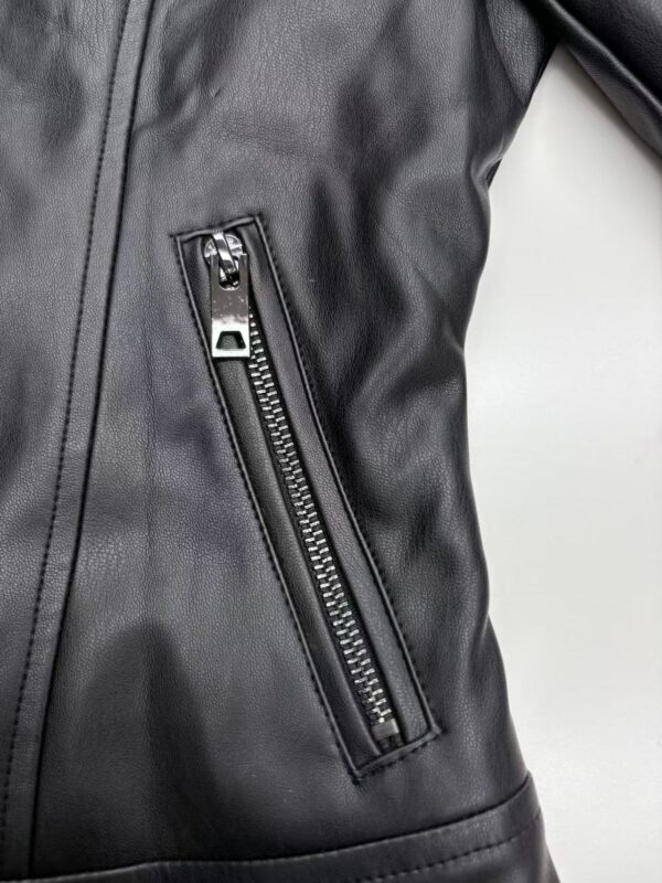 Close-up of a black leather jacket featuring a vertical zipper pocket, showcasing high-quality material and stylish design for fashion enthusiasts.