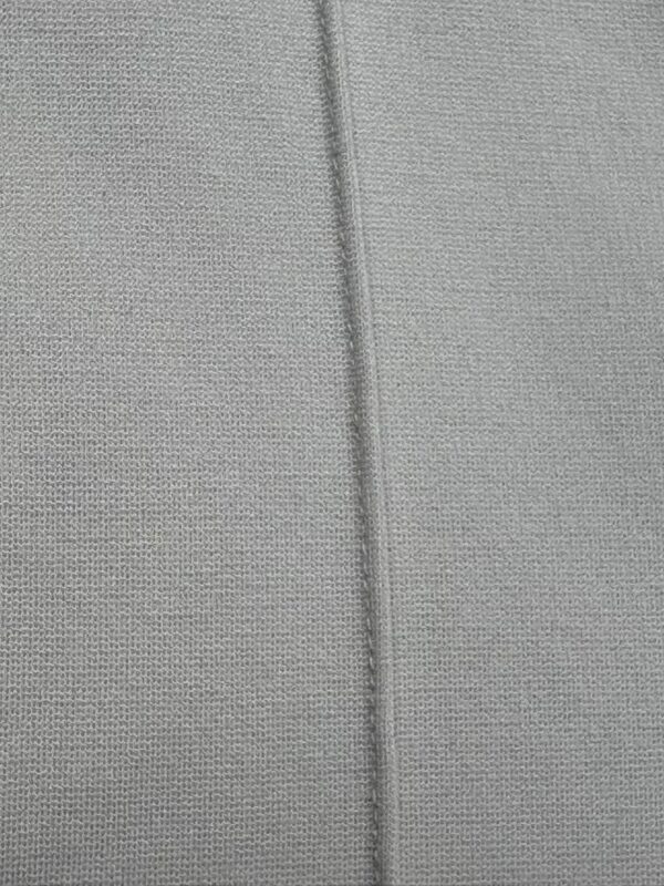 Detailed close-up of grey fabric showing fine woven texture and a central seam, ideal for fashion or textile product images.