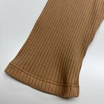 Close-up of a brown ribbed knit sweater sleeve with detailed stitching and texture, showcasing high-quality fabric and craftsmanship.