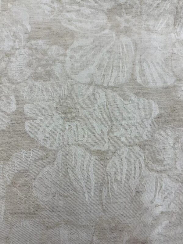 Close-up of fabric with a beach shell pattern in neutral tones, ideal for fashion and home decor projects.