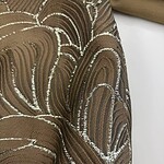 Close-up of luxurious brown fabric with intricate silver embroidery, perfect for high-end fashion or interior decor.