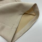 Close-up of a beige suit jacket showing the inner pocket and smooth fabric texture, perfect for formal or business wear.