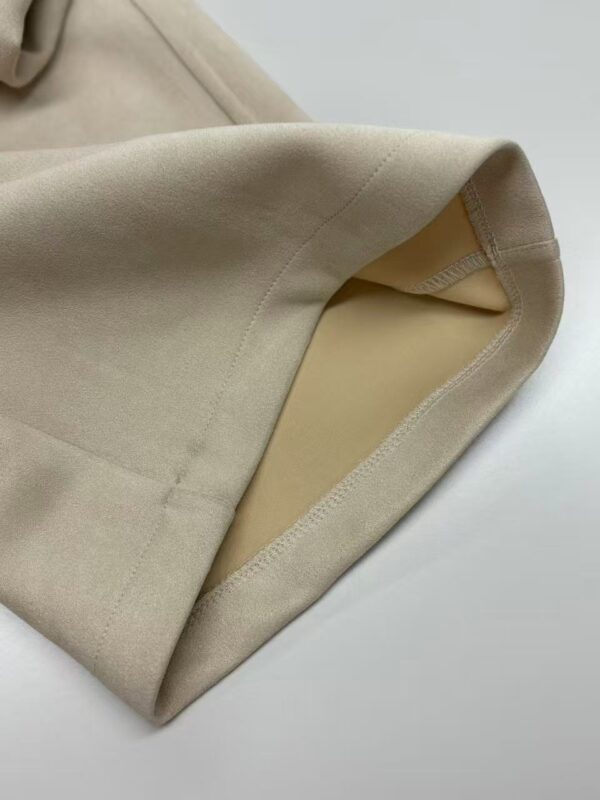 Close-up of a beige suit jacket showing the inner pocket and smooth fabric texture, perfect for formal or business wear.