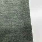 Close-up of green fabric textile material suitable for fashion and apparel design, showing detailed texture and weave pattern.