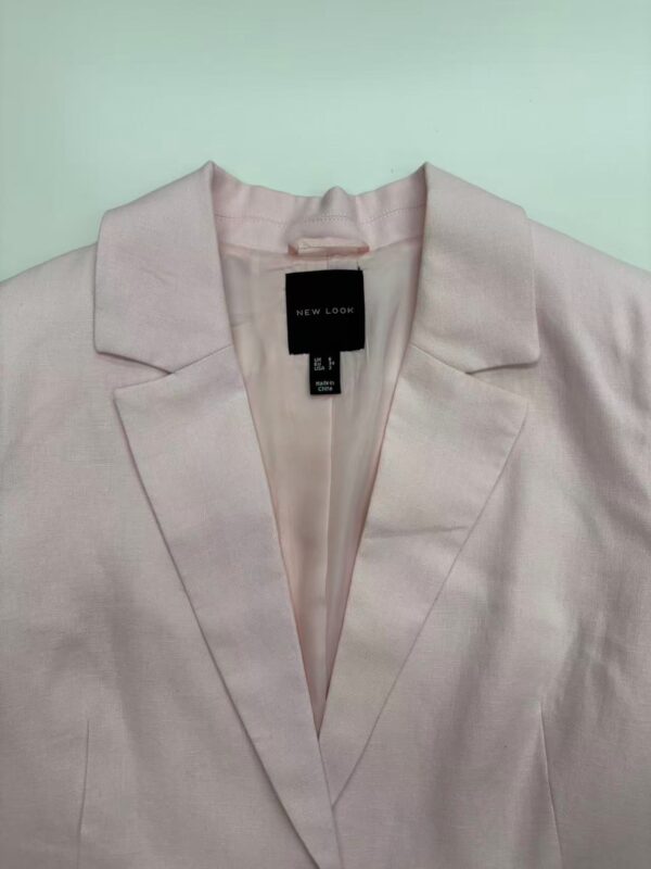 Light pink women's blazer with classic lapel design, perfect for professional or casual wear, made from high-quality fabric for a stylish look.