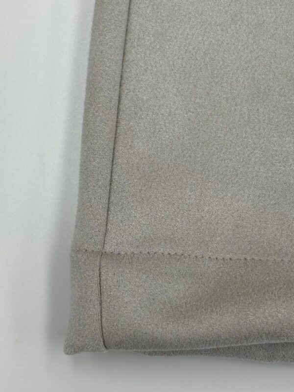 Close-up of a grey fabric sofa corner showing detailed stitching and smooth texture, ideal for modern living room decor.