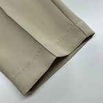 Close-up of beige blazer fabric showing smooth texture and tailored stitching for stylish professional wear.