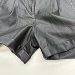 Close-up of stylish black leather shorts with belt and detailed stitching, perfect for trendy casual or night-out outfits.