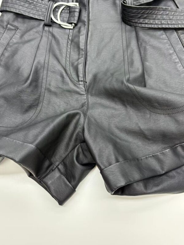 Close-up of stylish black leather shorts with belt and detailed stitching, perfect for trendy casual or night-out outfits.