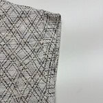 Close-up of a fabric with a detailed geometric pattern in neutral tones, suitable for fashion and apparel design.