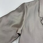 Close-up of a luxurious satin blouse with a tailored collar and puffed sleeve, perfect for formal or evening wear.