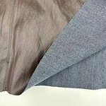 Close-up of a brown leather surface with a gray fabric lining, showing texture and stitching details.