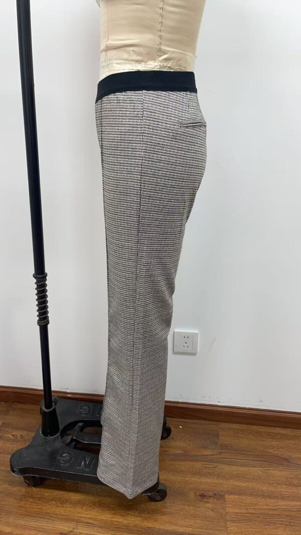 Close-up of women's checkered trousers with a black waistband, suitable for professional or casual wear, displayed on a mannequin.