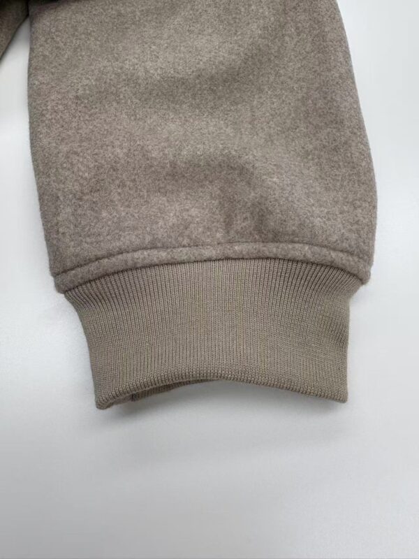 Close-up of a beige sweatshirt cuff showing soft fabric and ribbed knit design, ideal for casual fashion and comfortable wear.