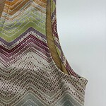 Close-up of a vibrant, zigzag patterned textile with multicolored threads, showcasing intricate craftsmanship and detailed weaving.