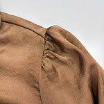 Close-up image of a brown leather jacket shoulder showing detailed stitching and texture for fashion and apparel SEO.