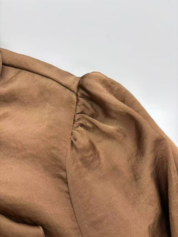 Close-up image of a brown leather jacket shoulder showing detailed stitching and texture for fashion and apparel SEO.
