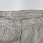 Close-up of beige casual pants with elastic waistband, suitable for everyday wear and relaxed fashion styles.