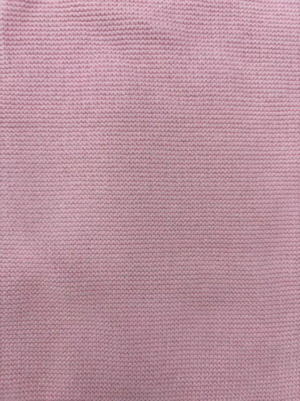 Close-up of pink knitted fabric showcasing fine texture and detailed stitching, ideal for fashion and textile design.