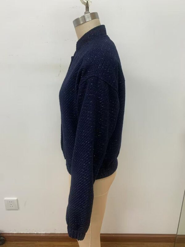 Close-up of a navy blue knitted sweater displayed on a mannequin, showcasing its textured fabric and cozy design.