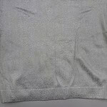 Close-up of a silver knit sweater with a round neckline, soft texture, and subtle shimmer, perfect for casual or formal wear.