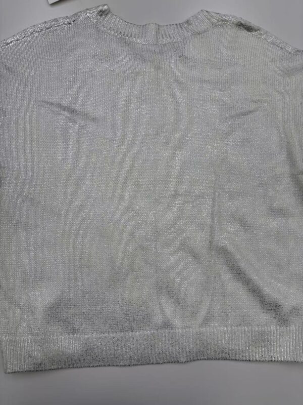 Close-up of a silver knit sweater with a round neckline, soft texture, and subtle shimmer, perfect for casual or formal wear.