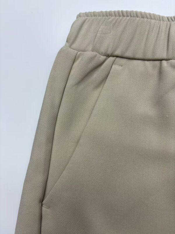 Close-up of beige casual women's pants with elastic waistband and side pocket, suitable for everyday wear and comfortable fashion.