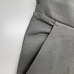 Close-up of grey tailored men's pants showing fabric texture and pocket detail, perfect for modern fashion and professional wear.