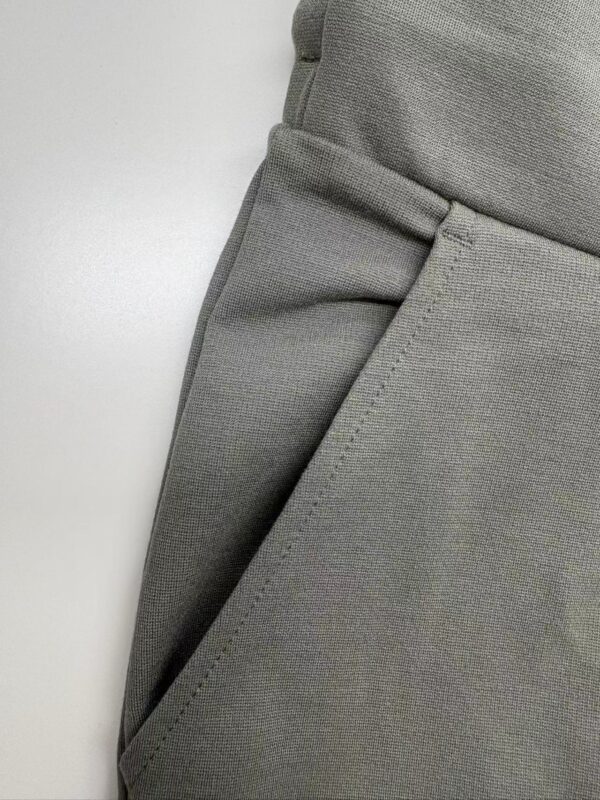 Close-up of grey tailored men's pants showing fabric texture and pocket detail, perfect for modern fashion and professional wear.
