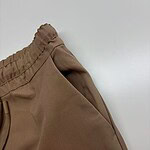 Close-up of brown jogger pants with elastic waistband, made of comfortable fabric, suitable for casual wear and sports activities.