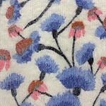 Close-up of fabric with a floral pattern featuring blue, pink, and black colors, suitable for fashion and textile projects.