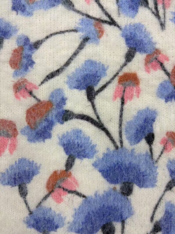 Close-up of fabric with a floral pattern featuring blue, pink, and black colors, suitable for fashion and textile projects.