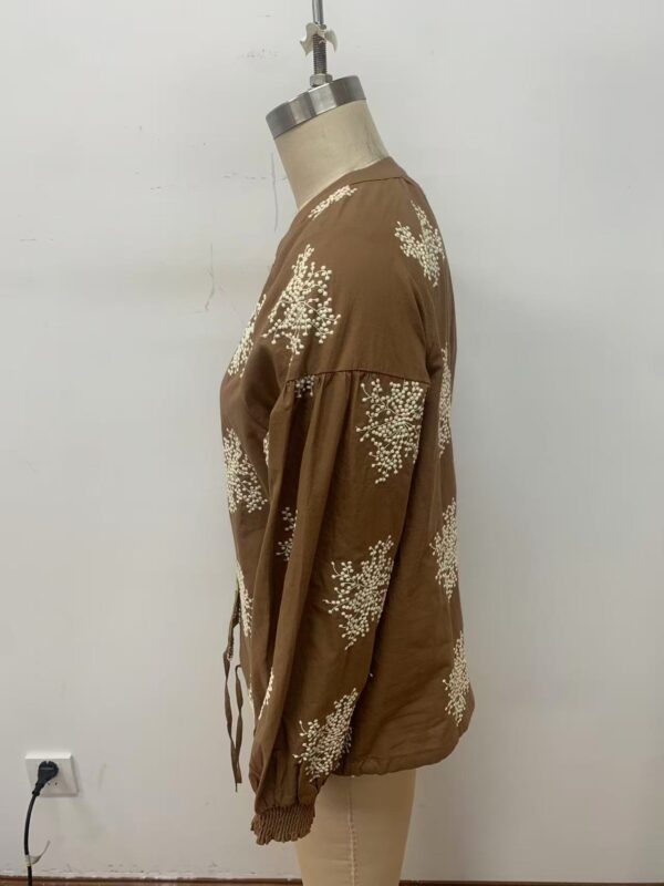 Stylish brown jacket with white floral patterns, long sleeves, and a relaxed fit, perfect for casual or semi-formal wear.