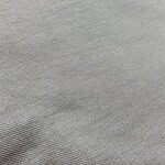 Close-up of smooth, light gray fabric with subtle weave pattern, ideal for fashion and apparel design.
