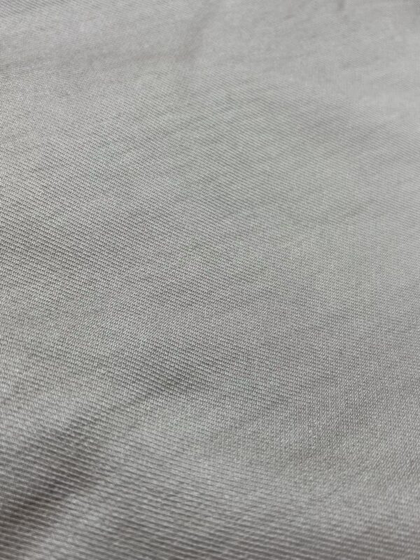 Close-up of smooth, light gray fabric with subtle weave pattern, ideal for fashion and apparel design.