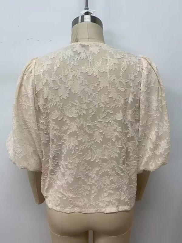 Cream-colored lace blouse with floral embroidery and puffed sleeves, perfect for formal or special occasions.