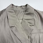 Close-up of a beige satin blazer with a notched lapel, tailored fit, and smooth fabric, perfect for stylish office wear or formal occasions.
