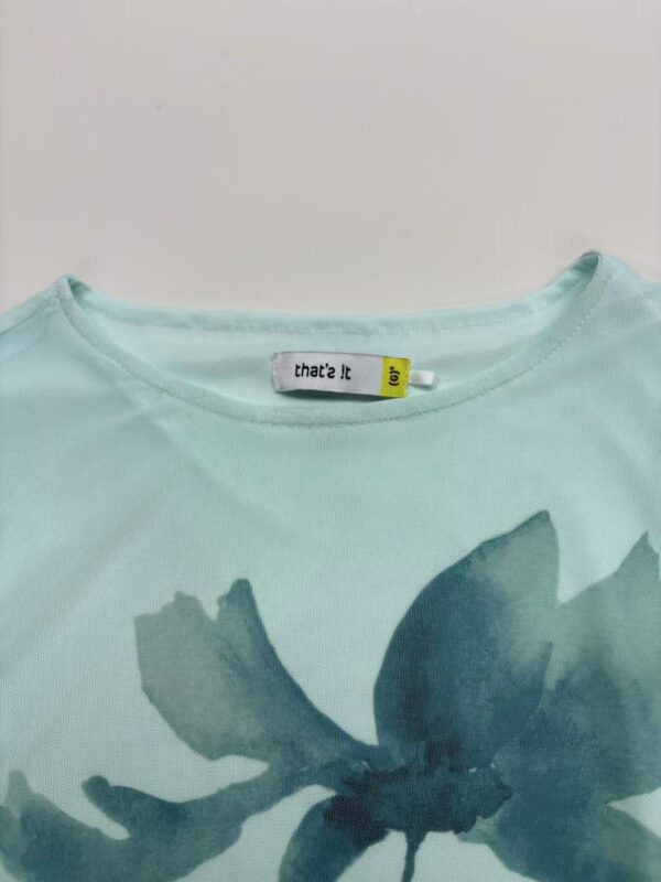 Light blue women's T-shirt with a large floral print in darker blue shades, casual and stylish for everyday wear.